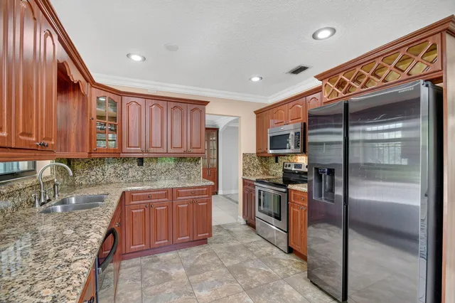 a kitchen with kitchen island granite countertop a sink and a window
