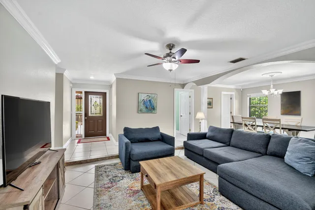 a living room with furniture a ceiling fan and a window