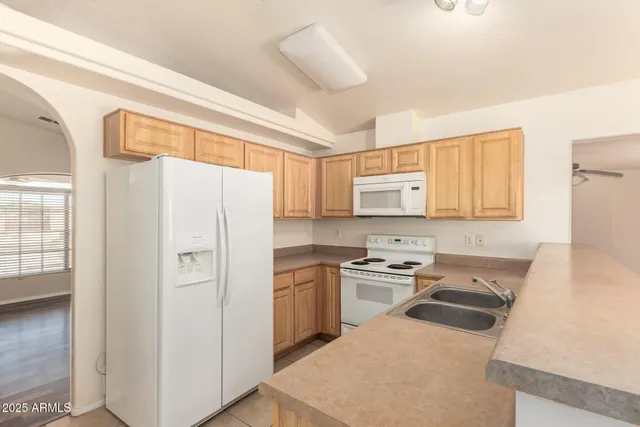 a kitchen with a refrigerator a stove a sink dishwasher and wooden cabinets