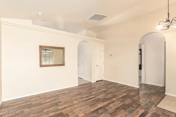 a view of a room with wooden floor and entryway
