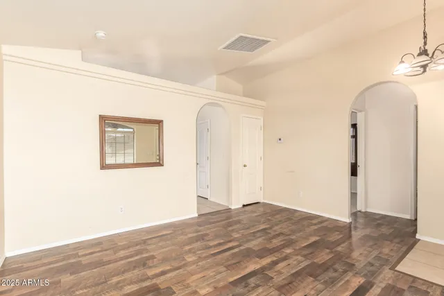 a view of a room with wooden floor and entryway