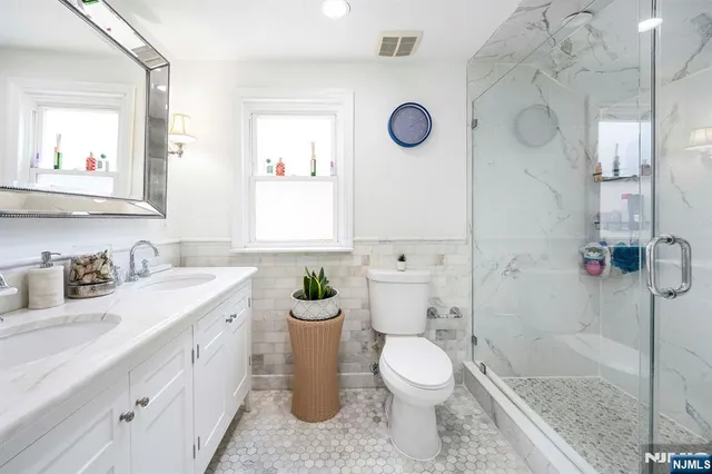 a bathroom with a granite countertop sink mirror vanity and toilet