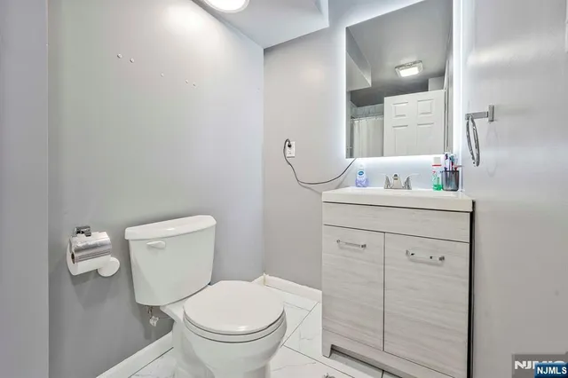 a bathroom with a toilet sink vanity and mirror