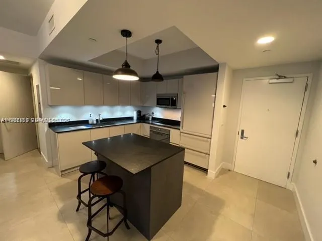 a kitchen that has a sink a microwave a stove and a refrigerator