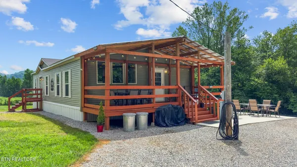 a view of a house with backyard porch and sitting area