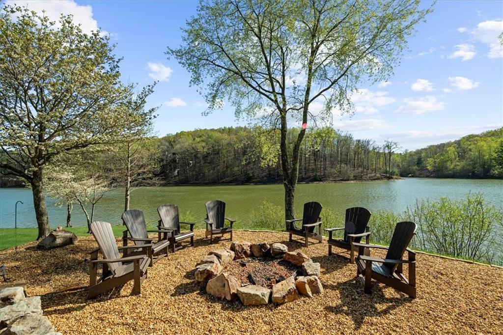 0 Waterside Trail Cleveland, GA 30528 - Photo 25 of 32 a view of a lake with couches and chairs under an umbrella