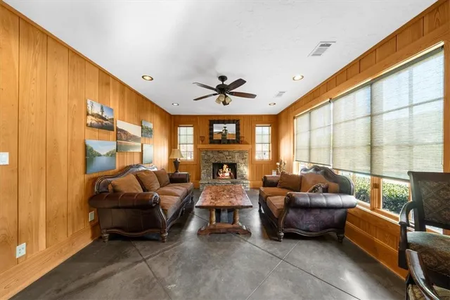a living room with furniture a ceiling fan and a large window