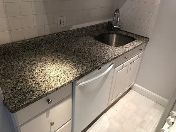 a kitchen with stainless steel appliances granite countertop a sink a stove and a refrigerator