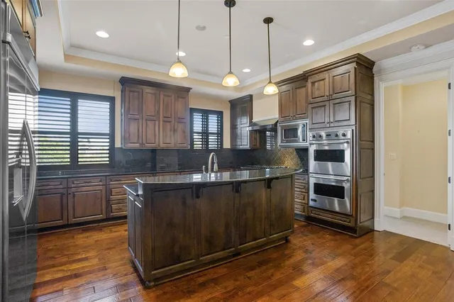 a kitchen with stainless steel appliances granite countertop a stove a sink and a refrigerator