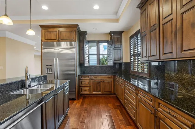 a kitchen with stainless steel appliances granite countertop a sink and wooden cabinets