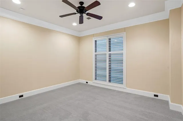 an empty room with a ceiling fan and window