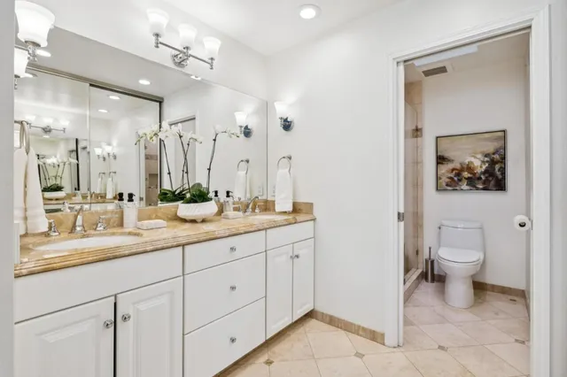 a bathroom with a granite countertop sink mirror and toilet