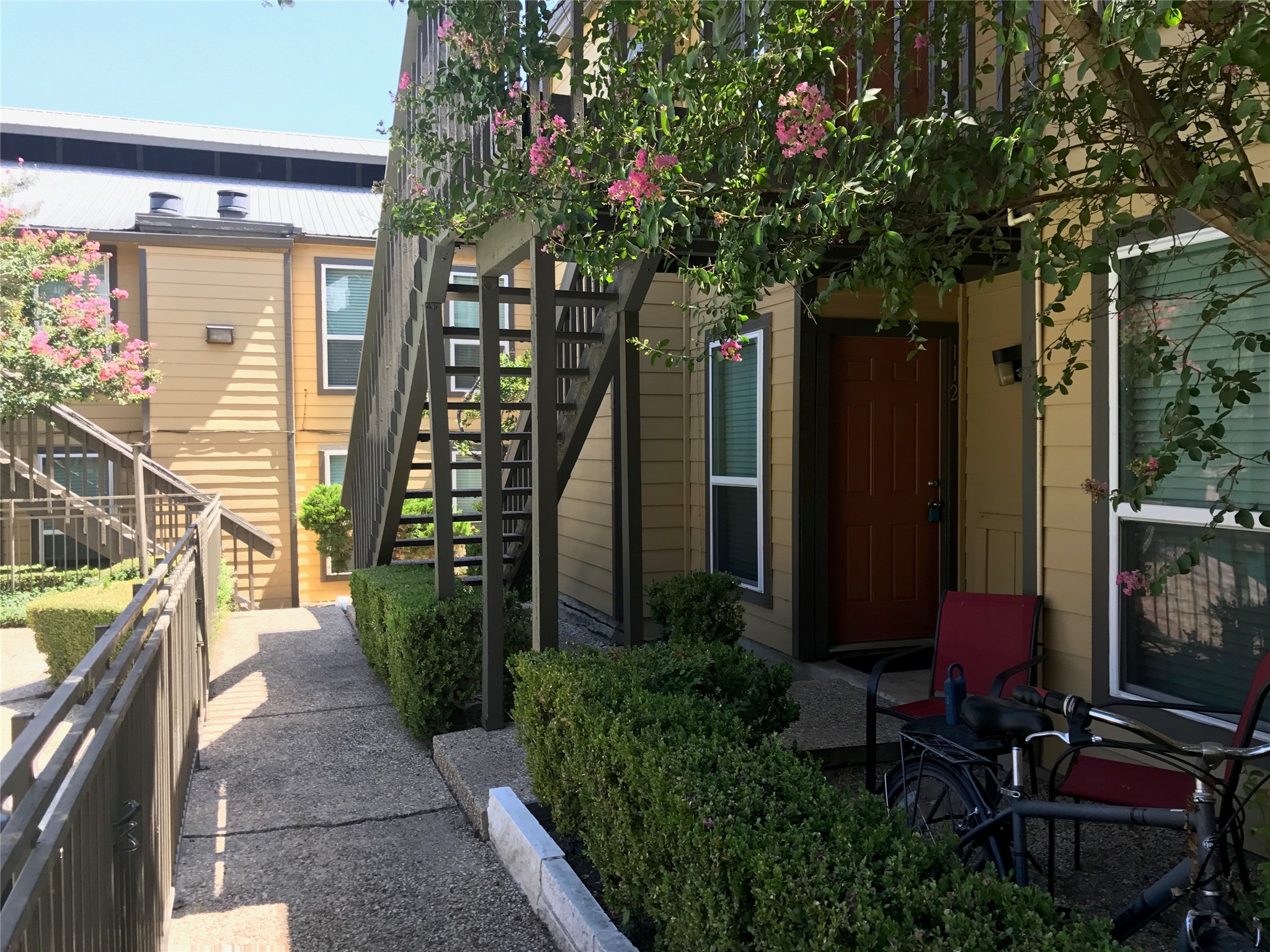 1000 West 26th Street, Unit 112 Austin, TX 78705 - Photo 11 of 14 a backyard of a house with lots of green space and glass windows