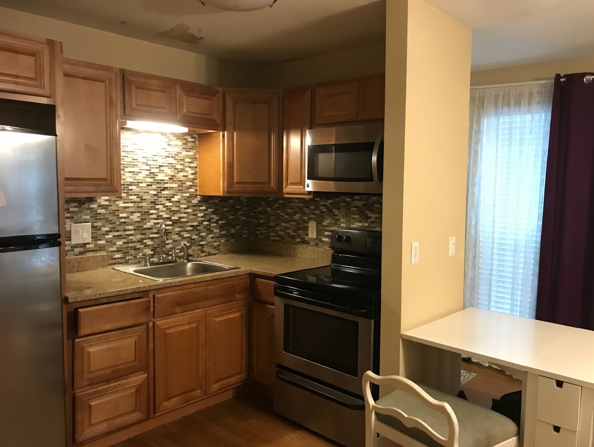 1000 West 26th Street, Unit 112 Austin, TX 78705 - Photo 6 of 14 a kitchen with a sink stove and refrigerator