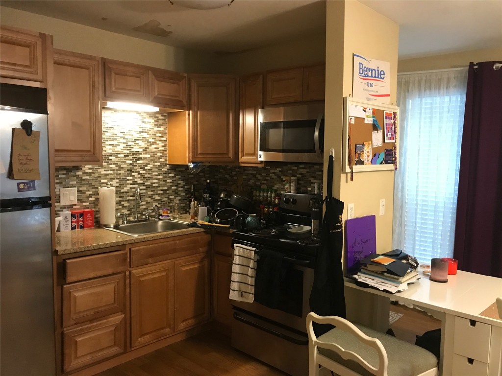 1000 West 26th Street, Unit 112 Austin, TX 78705 - Photo 7 of 15 a kitchen with a sink stove and refrigerator