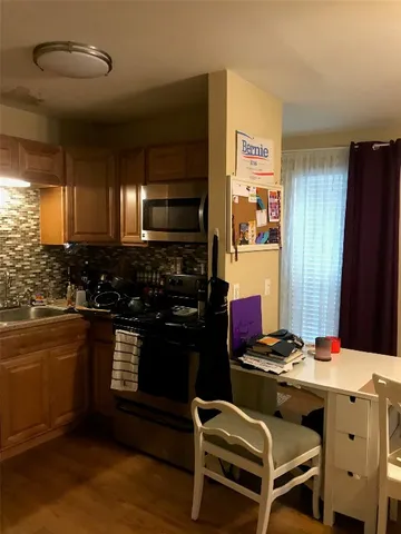 a kitchen with stainless steel appliances kitchen island granite countertop a sink stove and refrigerator