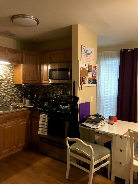 1000 West 26th Street, Unit 112 Austin, TX 78705 - Photo 8 of 15 a kitchen with stainless steel appliances kitchen island granite countertop a sink stove and refrigerator