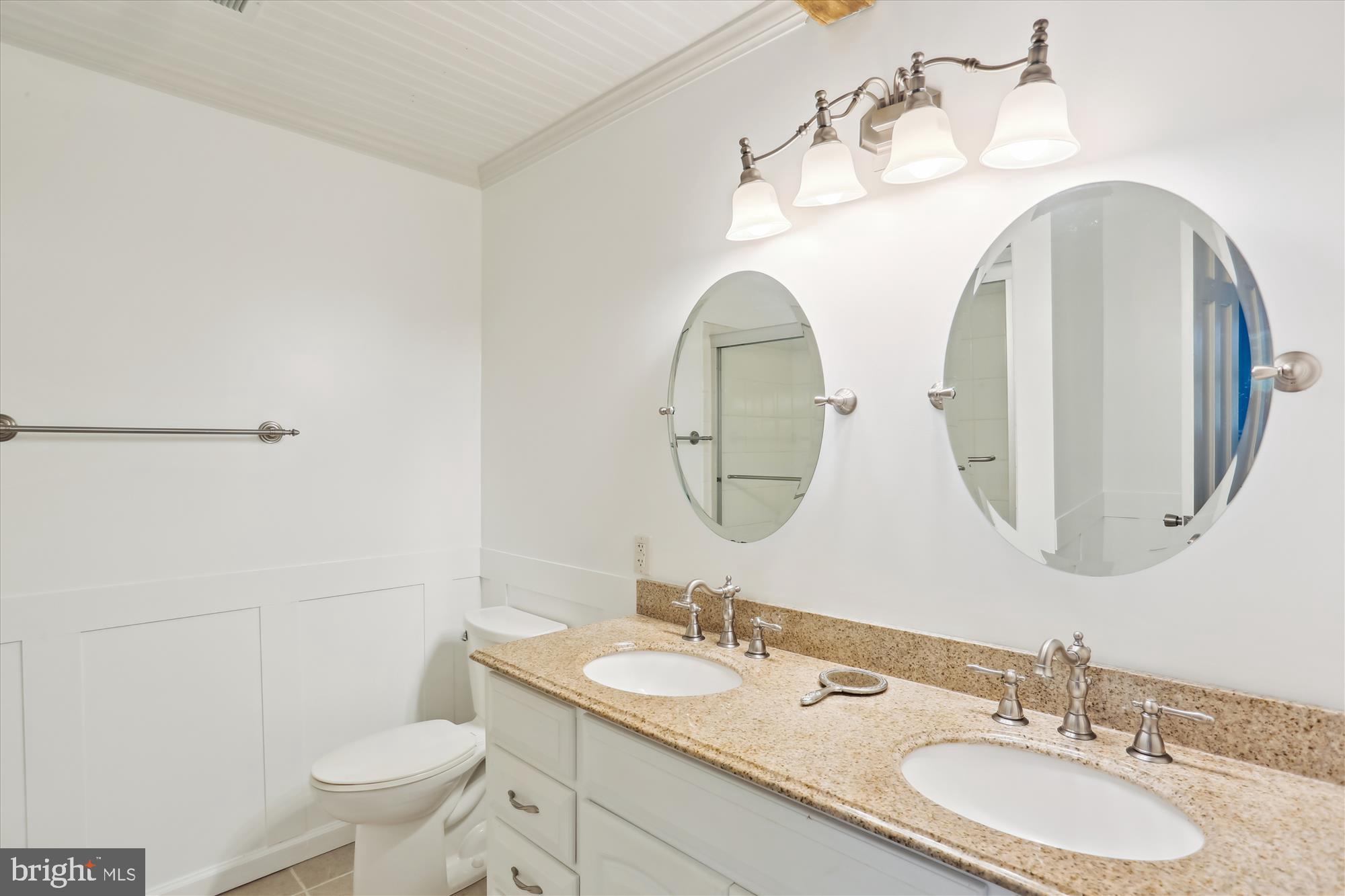 19500 Wootton Avenue Poolesville, MD 20837 - Photo 38 of 62 a bathroom with a granite countertop toilet a sink and a mirror