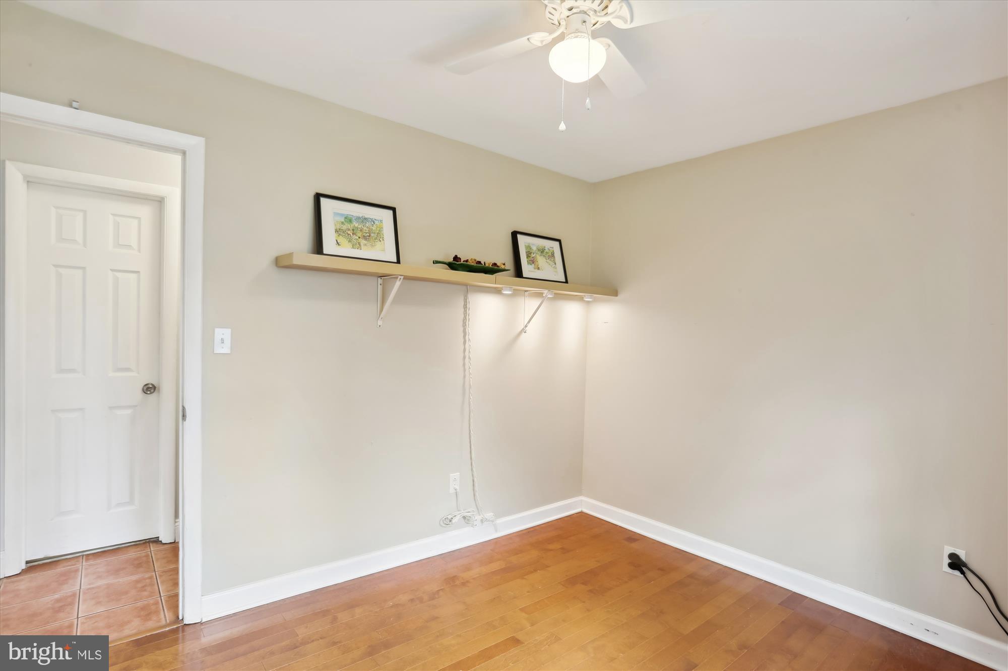 19500 Wootton Avenue Poolesville, MD 20837 - Photo 49 of 62 an empty room with a chandelier fan and wooden floor