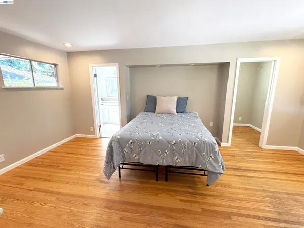 a bedroom with a bed and wooden floor