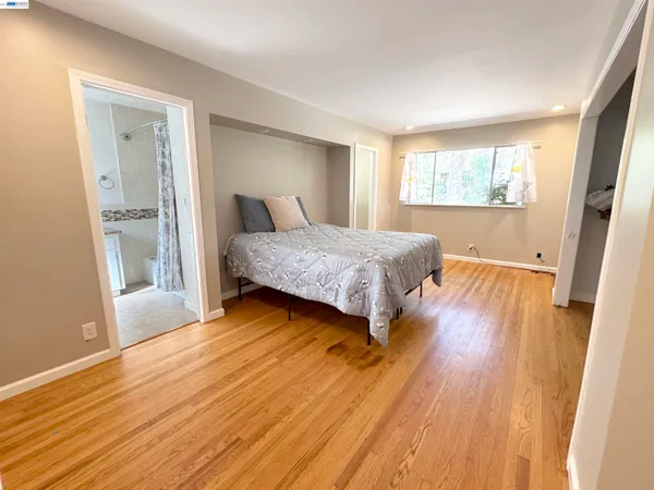 a bedroom with a bed and wooden floor