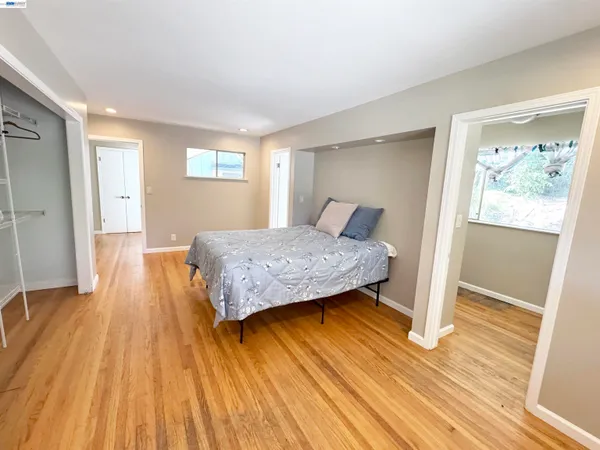 a bedroom with a bed and wooden floor