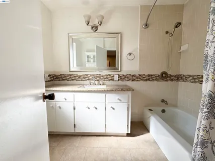a bathroom with a granite countertop sink double vanity and a bathtub