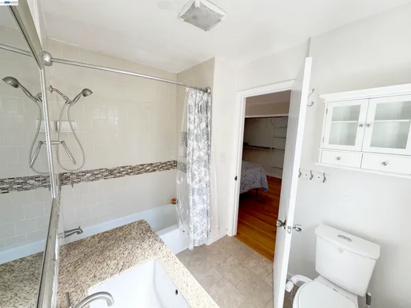 a bathroom with a granite countertop sink and a shower