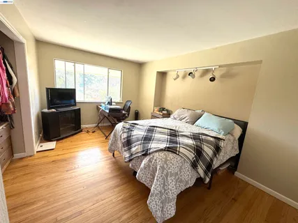 a bedroom with a bed and wooden floor