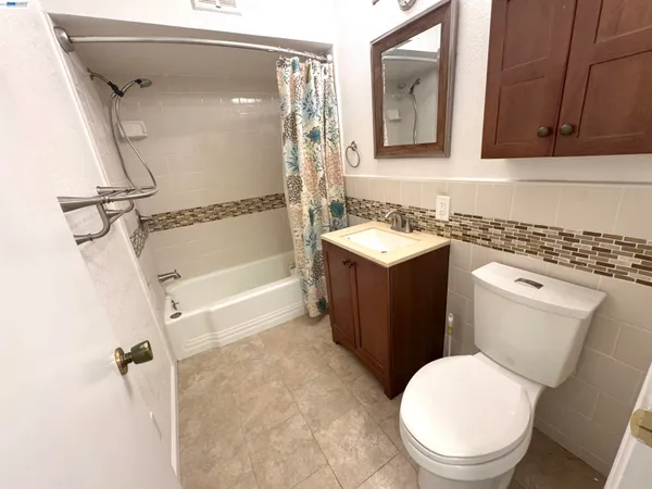 a bathroom with a granite countertop toilet sink and mirror