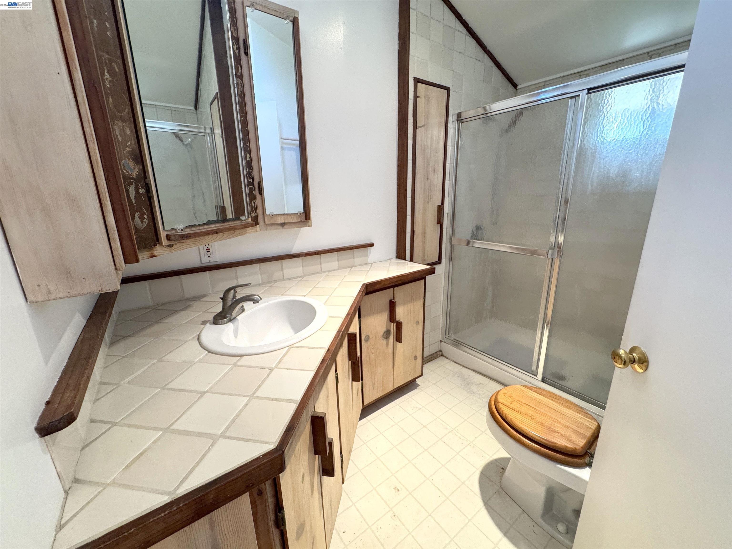 17121 Laurel Road Los Gatos, CA 95033 - Photo 25 of 43 a bathroom with a sink a toilet and mirror