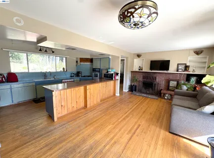 a kitchen with stainless steel appliances granite countertop a stove and a wooden floors