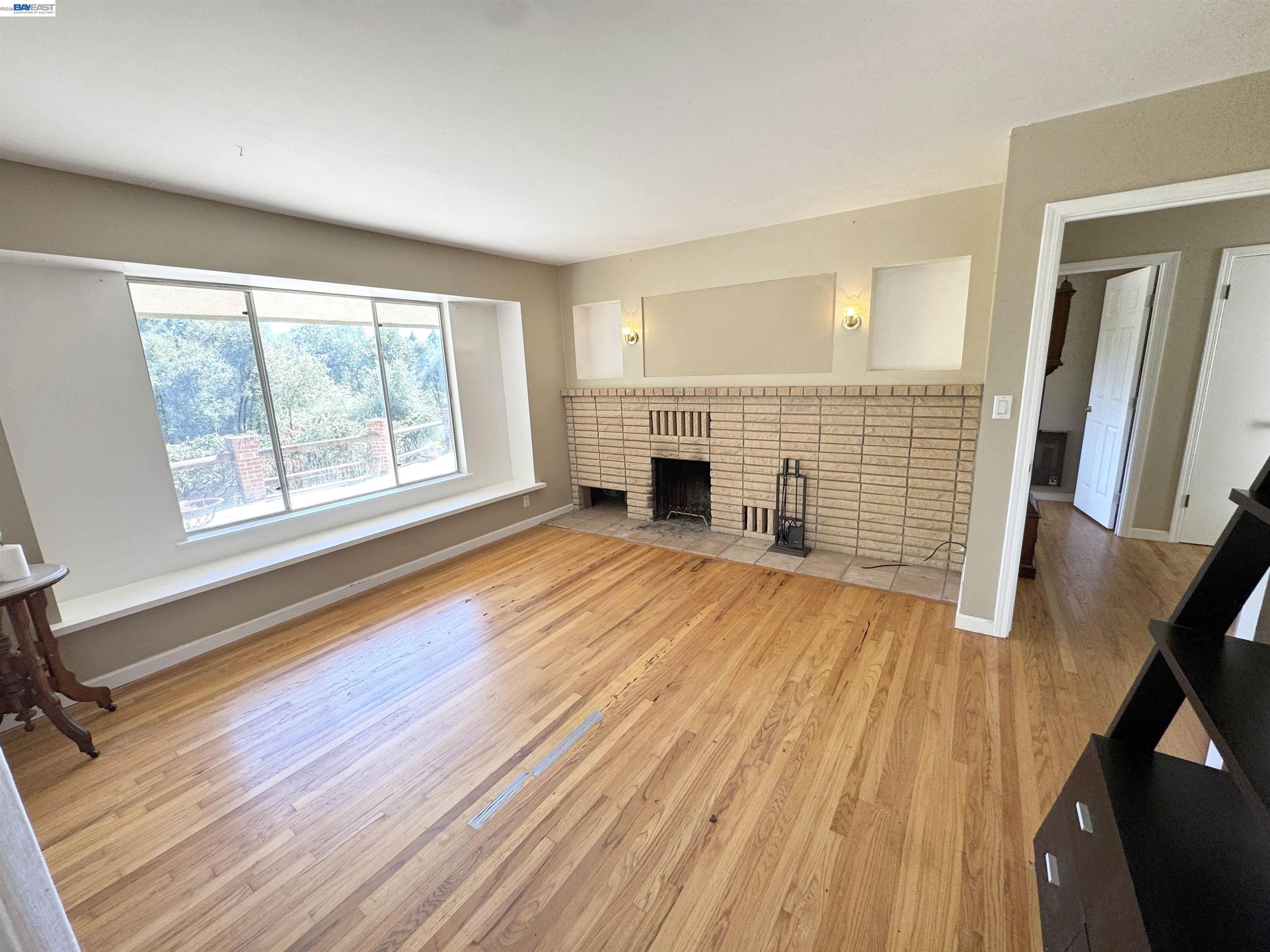 17121 Laurel Road Los Gatos, CA 95033 - Photo 8 of 43 a view of empty room with wooden floor and fireplace