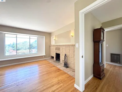 a view of empty room with wooden floor and fireplace