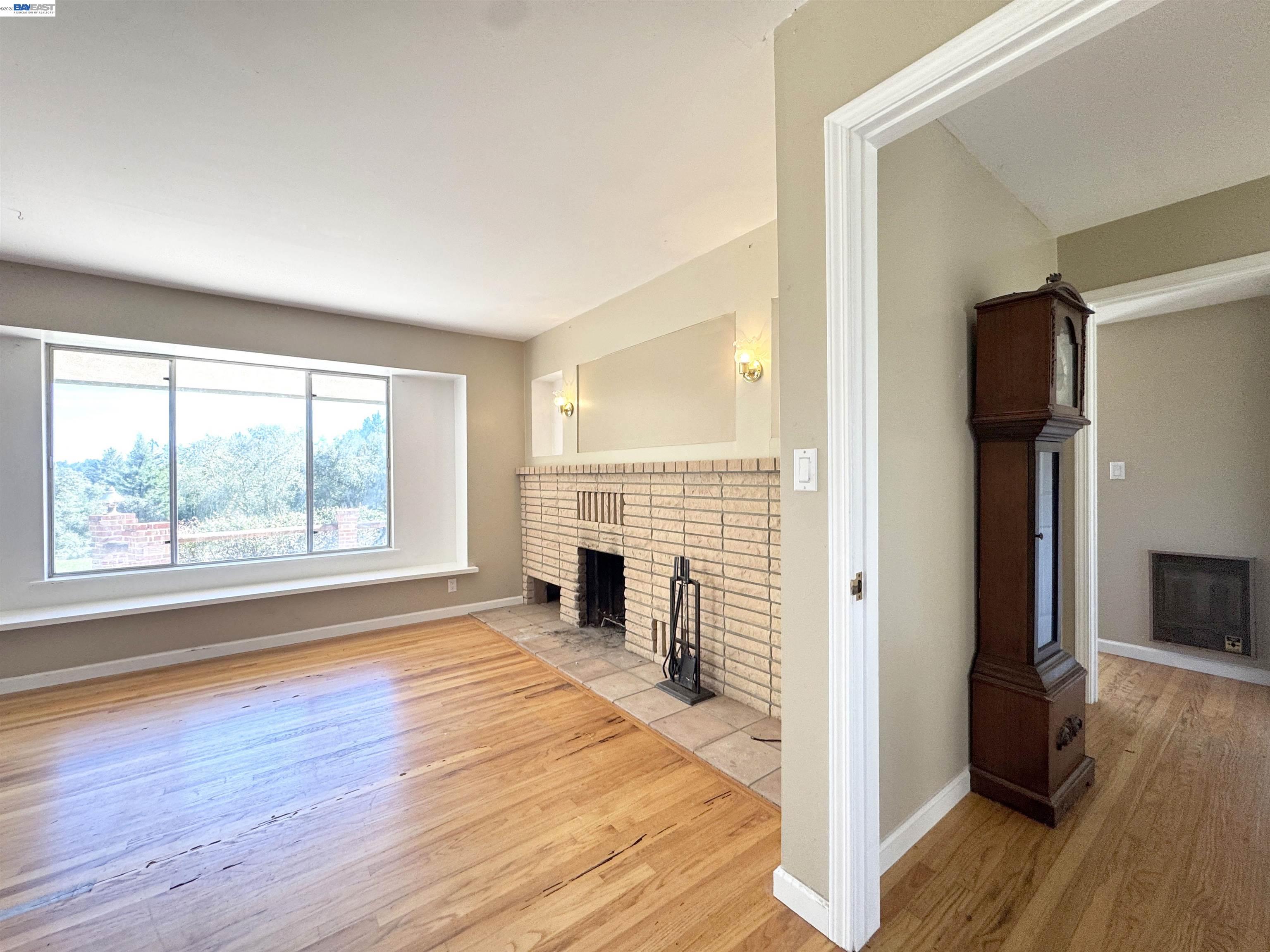 17121 Laurel Road Los Gatos, CA 95033 - Photo 9 of 43 a view of empty room with wooden floor and fireplace
