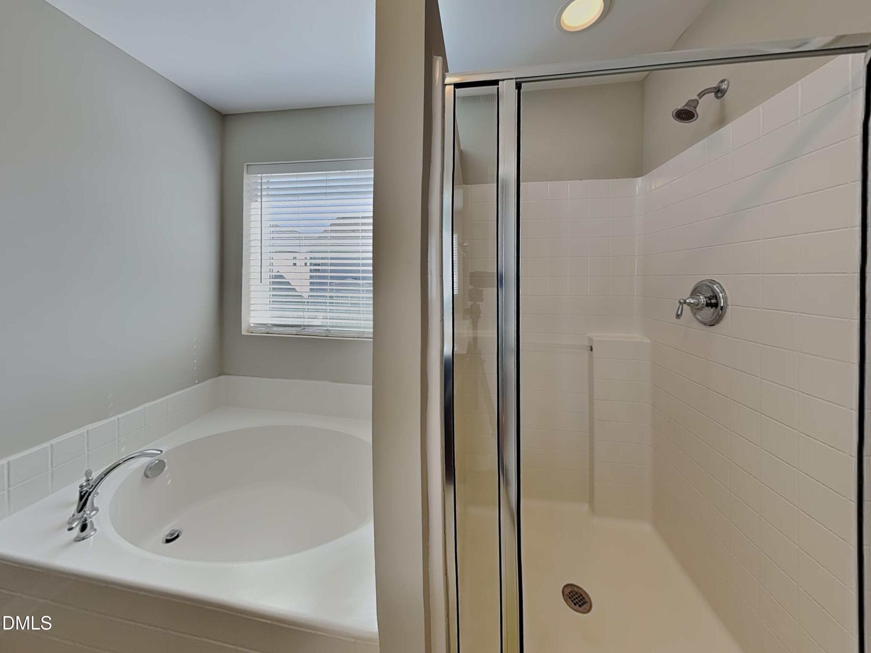 198 Outwater Ridge Drive Garner, NC 27529 - Photo 9 of 22 a white bath tub sitting next to a shower