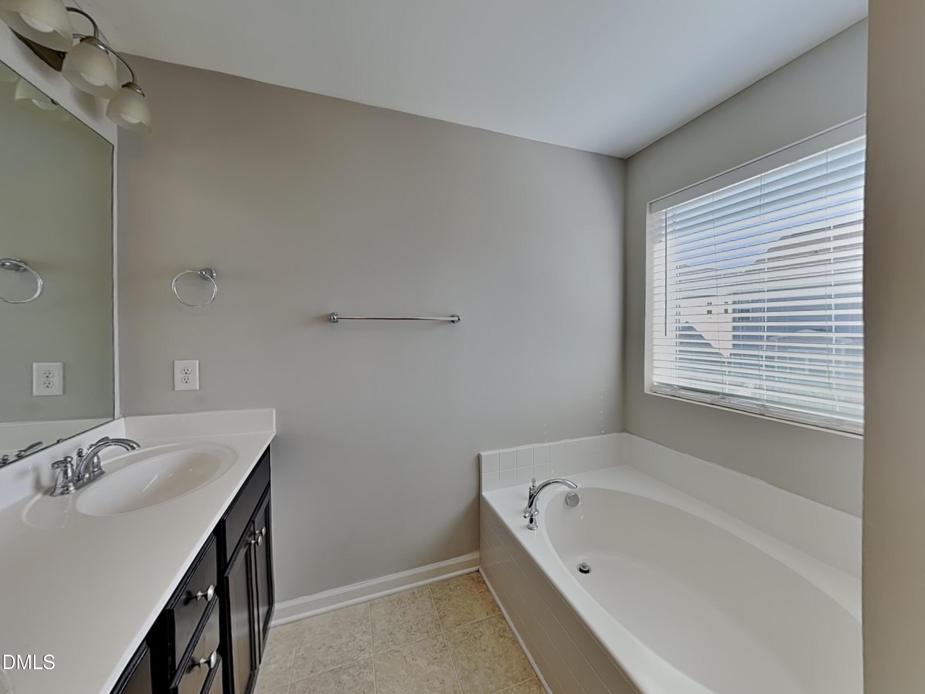 198 Outwater Ridge Drive Garner, NC 27529 - Photo 10 of 22 a bathroom with a tub sink and mirror