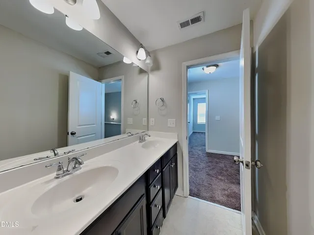 a bathroom with a double vanity sink mirror and