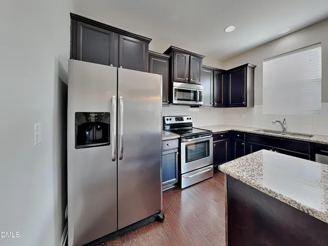 a kitchen with a refrigerator sink and stainless steel appliances