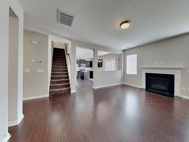 an empty room with wooden floor and fireplace