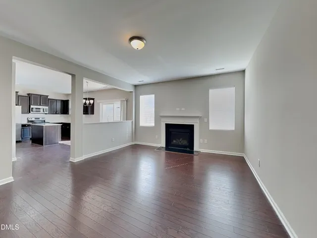 an empty room with wooden floor and fireplace