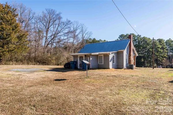 a front view of house with yard and trees in the background