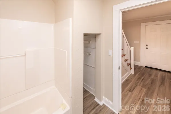 a view of a hallway with wooden floor and staircase