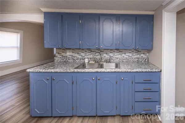 a kitchen with granite countertop wooden cabinets a sink and dishwasher