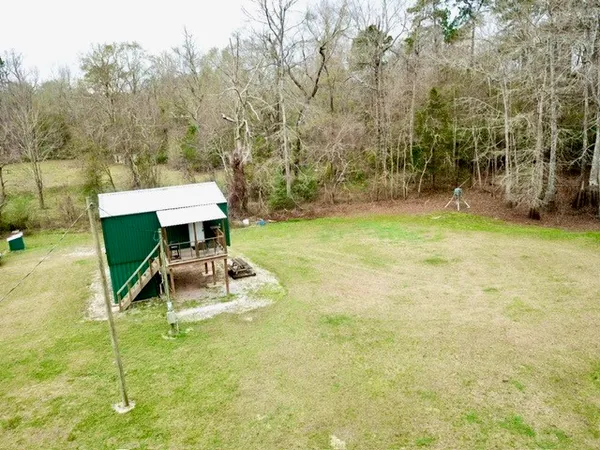 a backyard of a house with a yard and potted plants