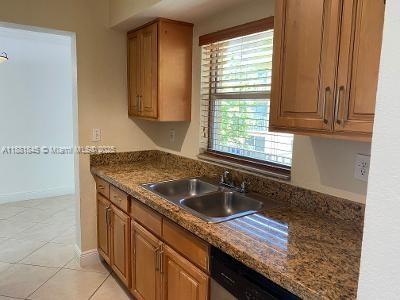 8601 Southwest 94th Street, Unit 227W Miami, FL 33156 - Photo 7 of 17 a kitchen with granite countertop a sink and a window