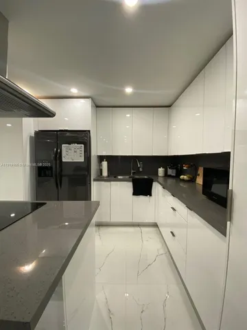 a large white kitchen with a sink and cabinets