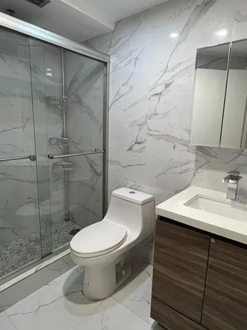 a bathroom with a sink toilet and shower