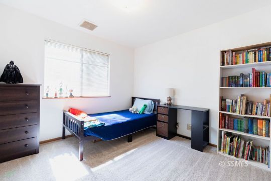 305 South Locust Street Ridgecrest, CA 93555 - Photo 25 of 36 a bedroom with a bed and a book shelf
