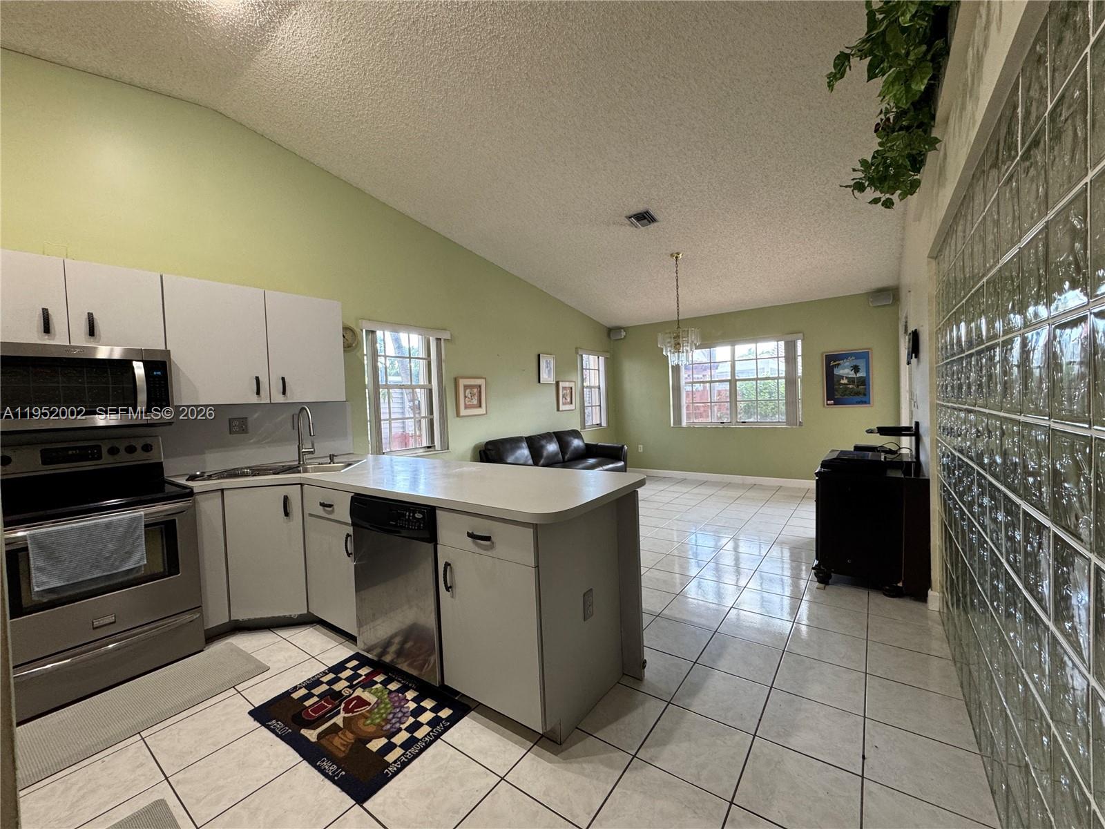 14241 Southwest 36th Street Miami, FL 33175 - Photo 3 of 18 a kitchen with a sink a stove top oven and cabinetry